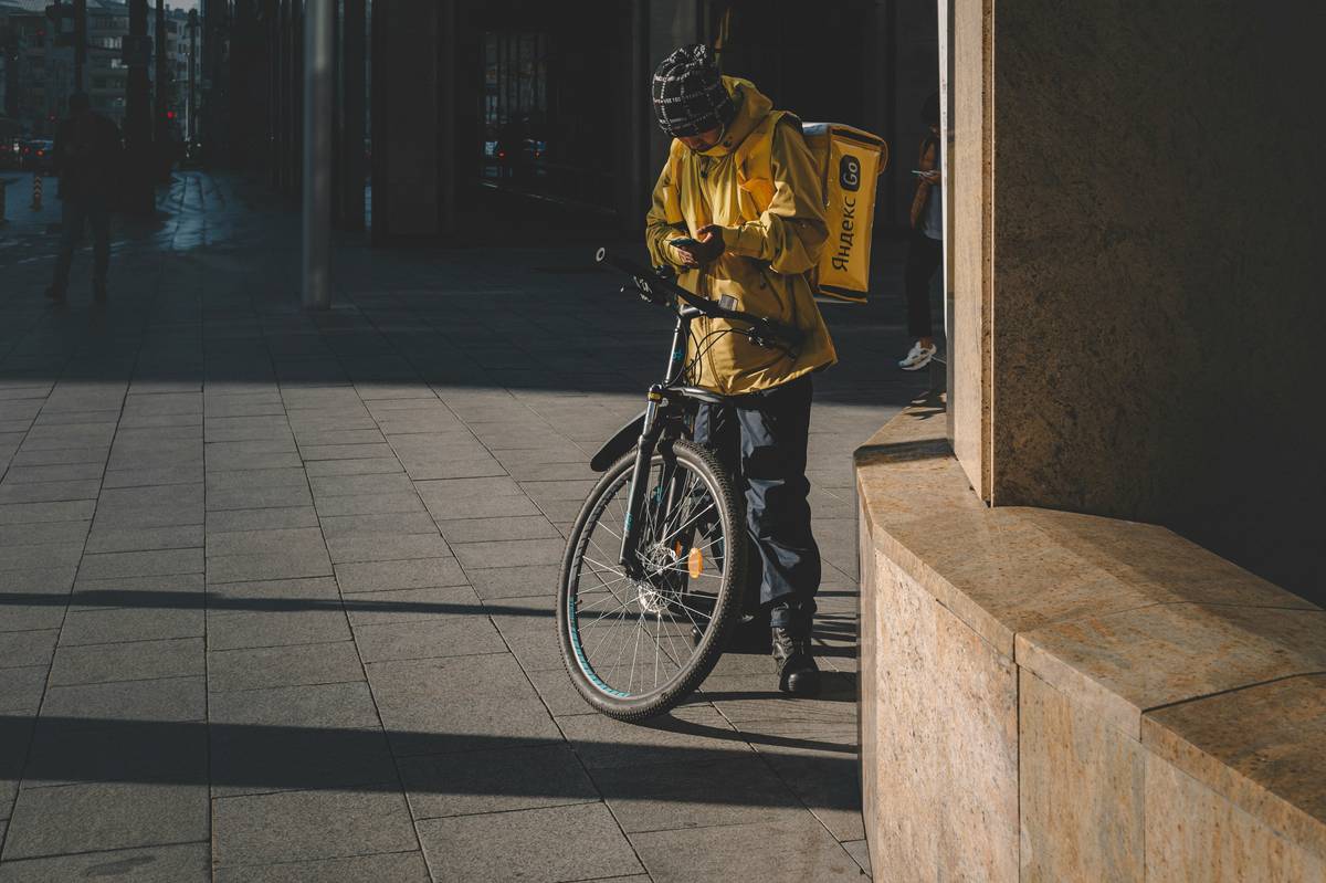 Cyclist wearing sleek, form-fitting Cyclist-Friendly Rain Gear riding through urban downpour
