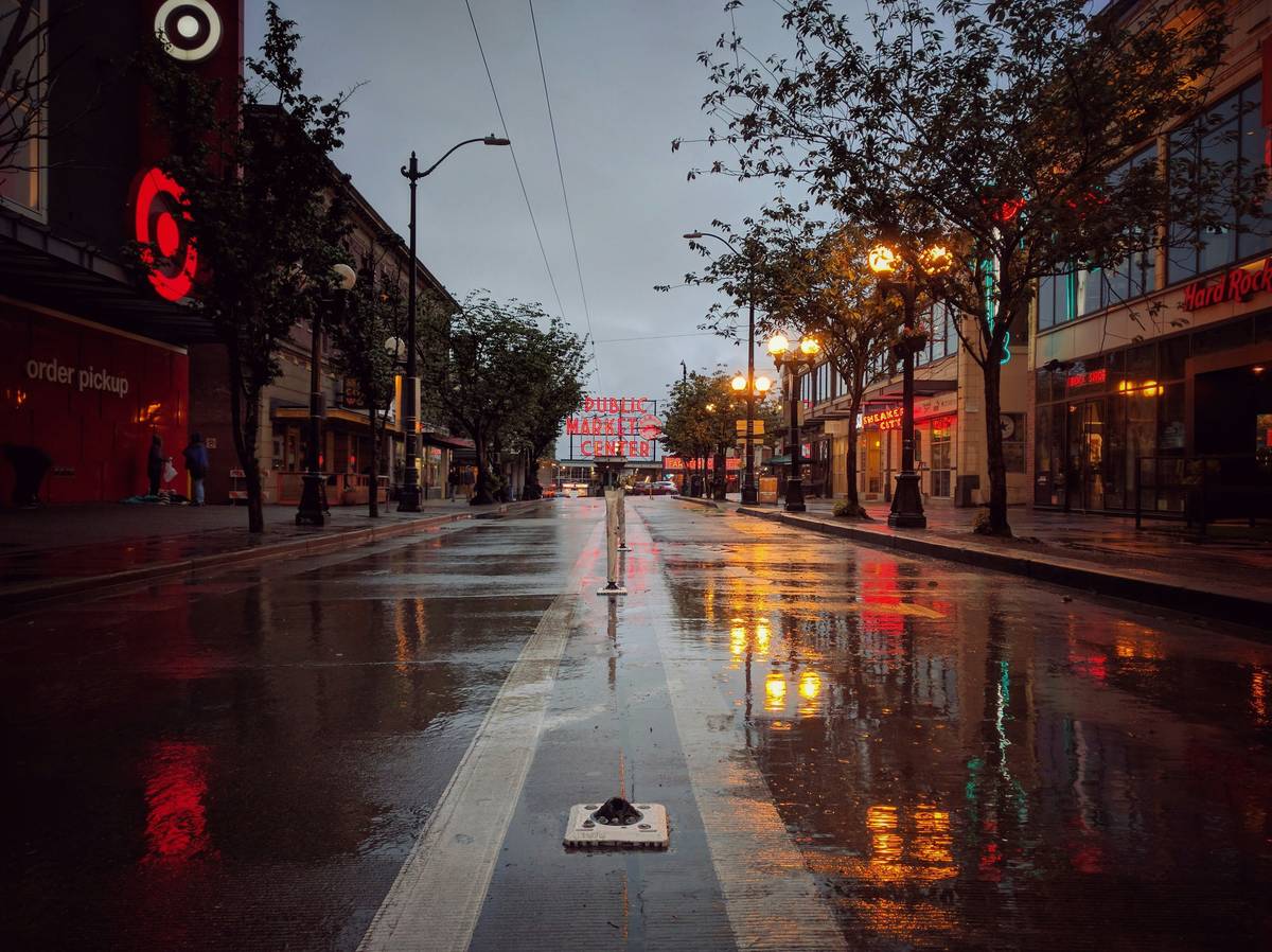 Traveler wearing Seamless Rain Gear hiking through heavy downpour with dry backpack