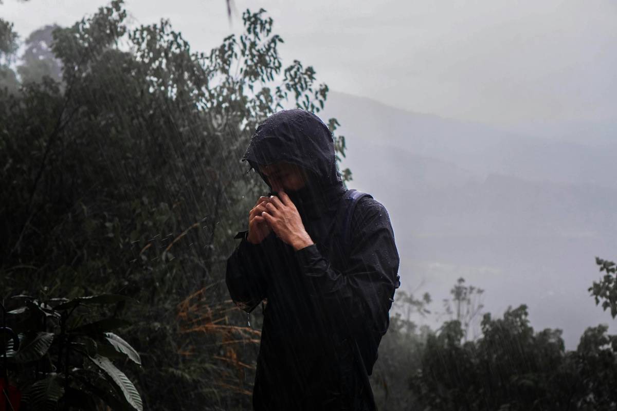 Hiker wearing breathable waterproof layers on misty trail, staying dry and comfortable