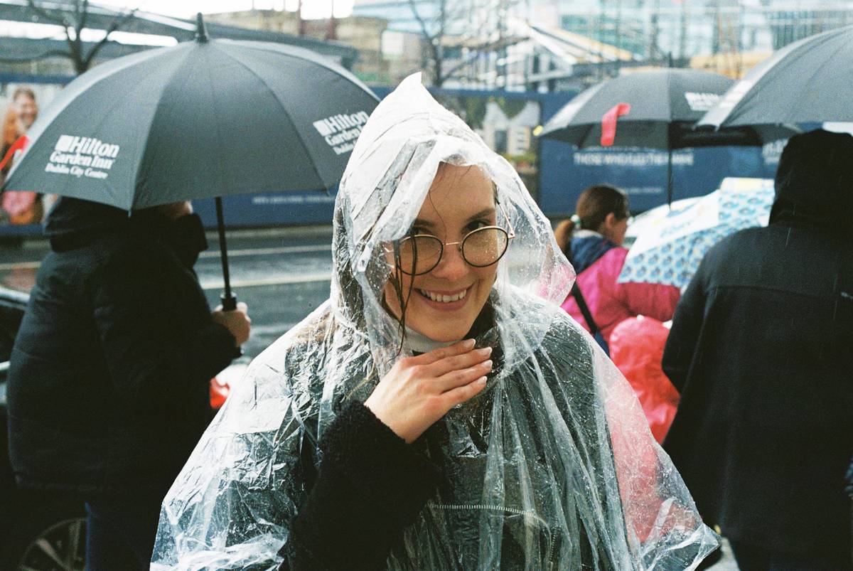 Traveler wearing Modular Rainwear Systems with detachable hood and breathable shell in drizzle